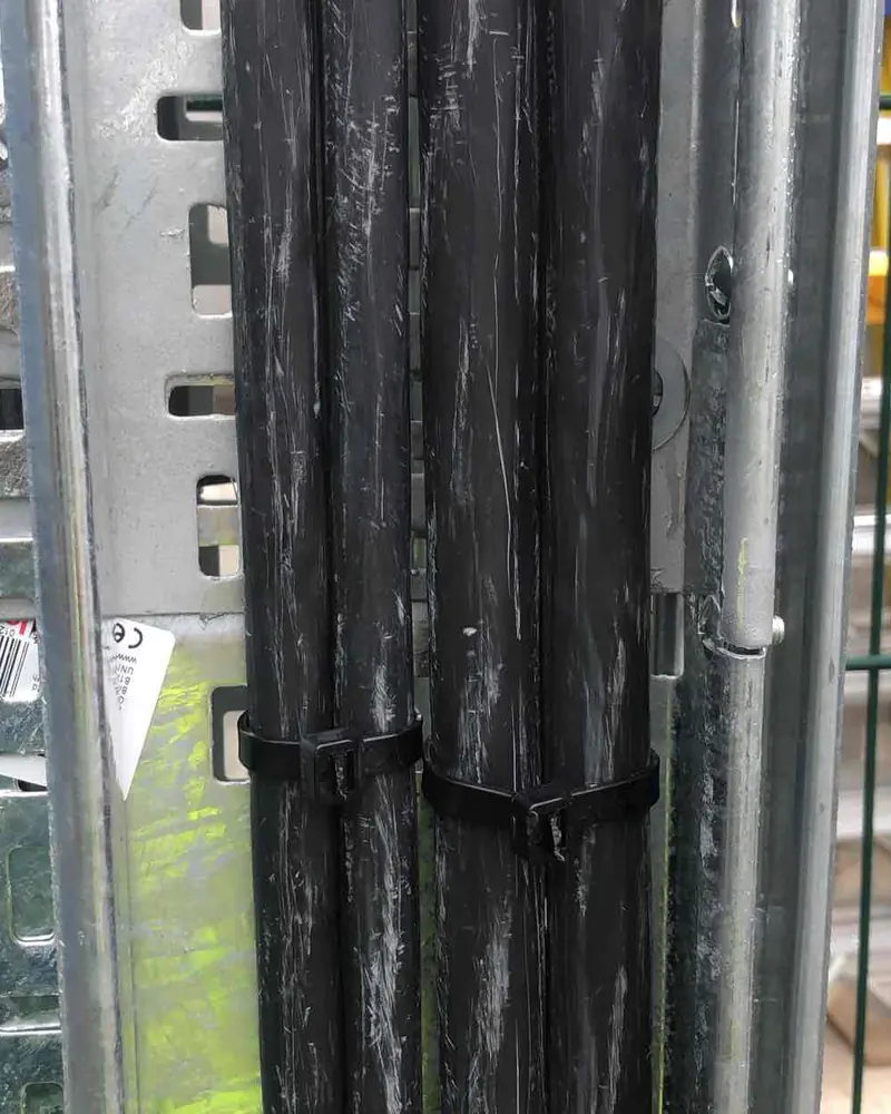 Black armoured cables fixed to galvanised cable tray on a commercial site