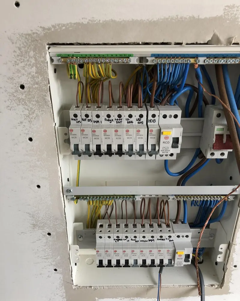 New dual-RCD consumer unit being wired, with each circuit breaker hand-labelled